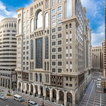 Al Aqeeq Madinah Hotel Medína Exteriér fotografie The photo depicts a large, modern building with a distinctive architectural style. The structure shows a blend of classic and contemporary design elements, featuring ornate details, large glass windows, and a prominent central facade. Surrounding the